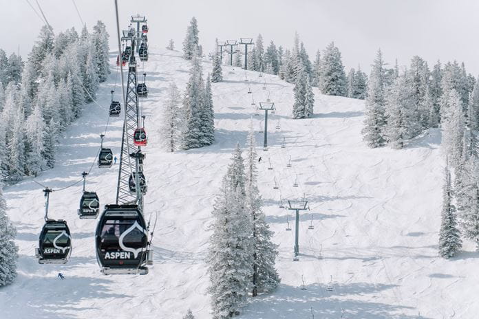 a ski lift going down a snowy mountain