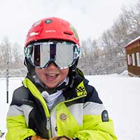 Young boy smiles during ski lesson