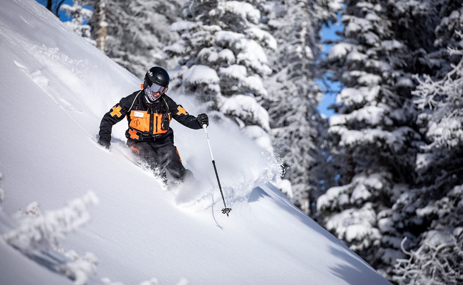 A ski patrol skier navigates a ski run at Aspen Snowmass