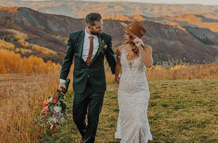 Bride and groom walk in fall at Snowmass