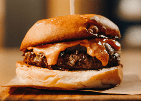 Burger dripping with cheese between buttery buns at Sams Snowmass