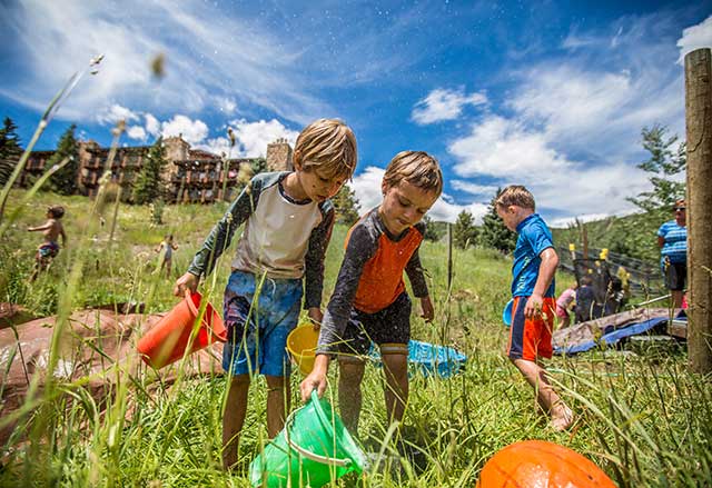 Kids exploring in the grass at Camp Aspen Snowmass
