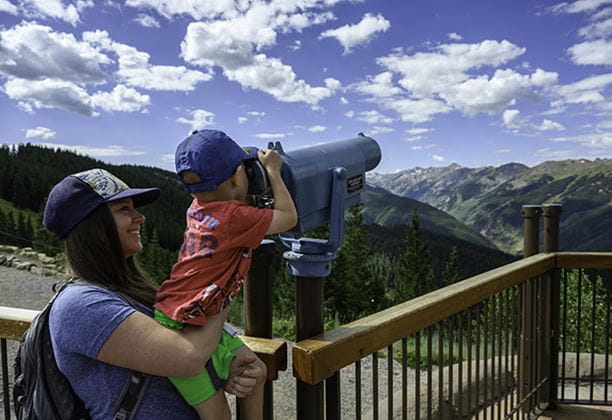 A mother and son looking through a telescope atop Aspen Mountain