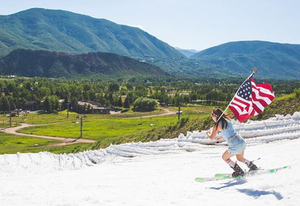 Skier in summer with an American flag for the Fourth of July