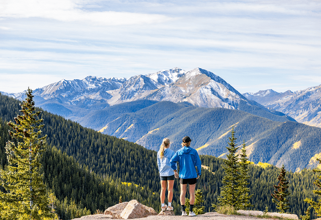 Two people look out over the vista at the top of aspen mountain