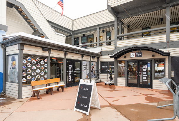 Exterior of four mountain sports in snowmass mall, stickers on windows on a cloudy day