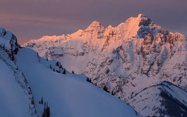 pink skies over white snowy peaks, on a winter day in Aspen