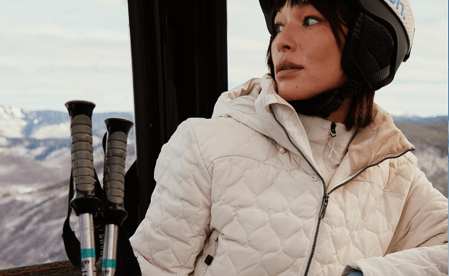 woman sits in Gondola in aspen collection gear
