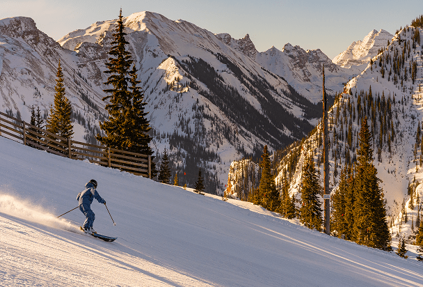 single skier on dusk lit slopes on a winter day in aspen colorado 