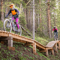 Two riders enjoy Snowmass Bike park bridges