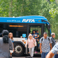 Group of people gets off a blue RFTA bus at the Maroon Bells
