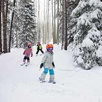 Kids ski through the trees at Buttermilk