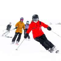 Group of people taking a lesson on a snowy day with low visibility