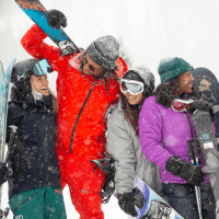 A group of people pose for the camera as it snows at aspen snowmass