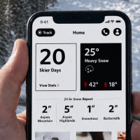 close up on hand holding phone with Aspen Snowmass app on the screen
