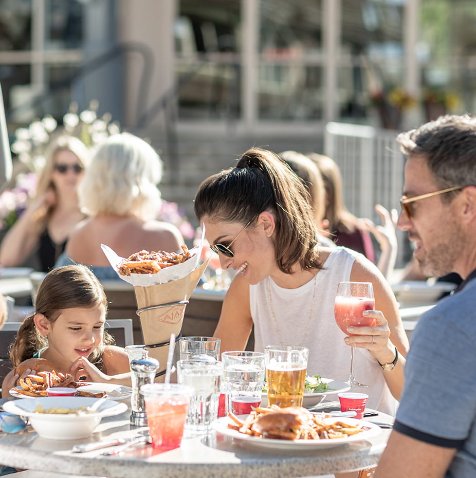 A family dines outdoor at Ajax Tavern at the base of Aspen Mountain.