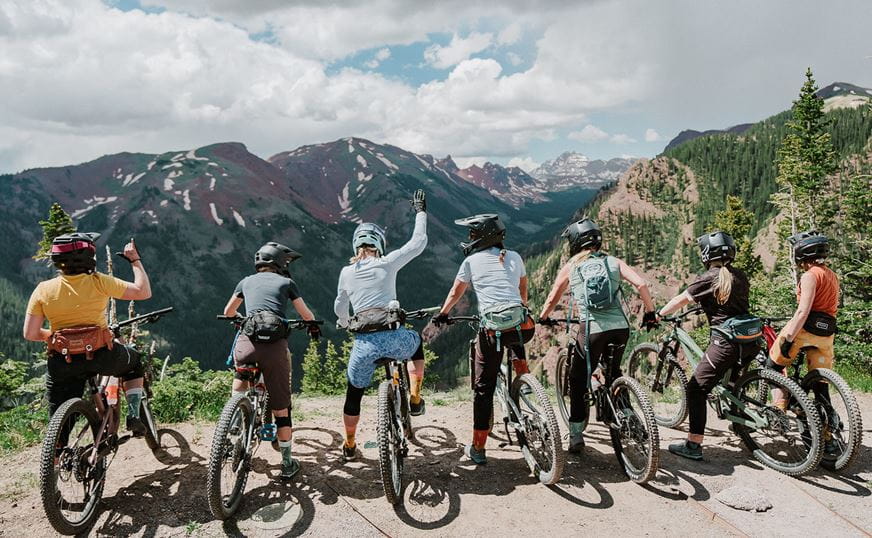 Women at the top of the Snowmass Bike Park, overlooking Maroon Bells Vista.