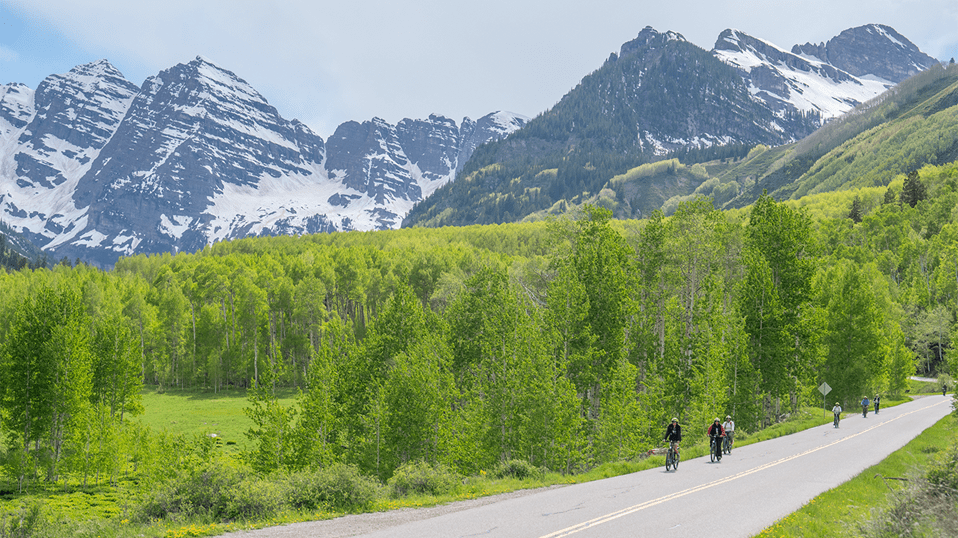 Bikers on the shoulder of the road riding up to Maroon Bells