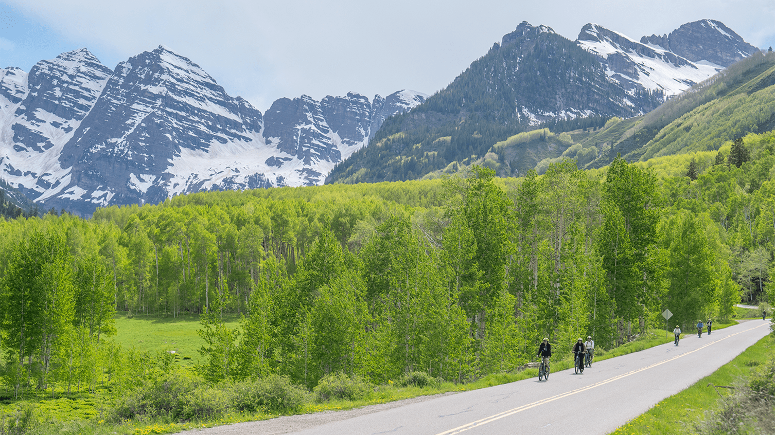 Bikers on the shoulder of the road riding up to Maroon Bells