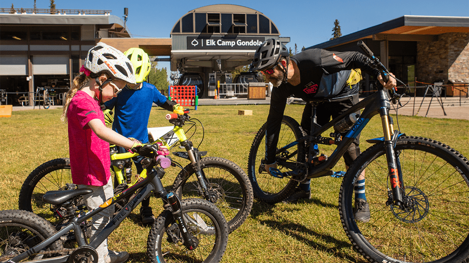 Bike coach educates two young bikers on bike anatomy 