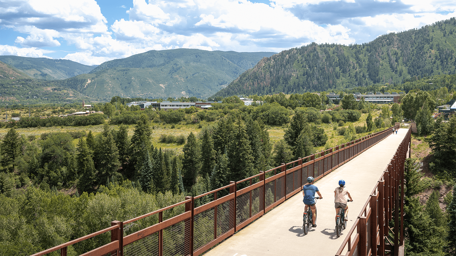 Couple rides over the bridge in Aspen Snowmass, on a leisurely cruise 