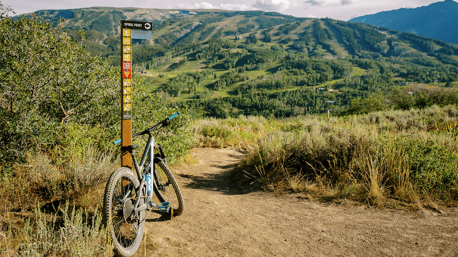 Mountain bike leaning against a direction pole at Aspen Snowmass