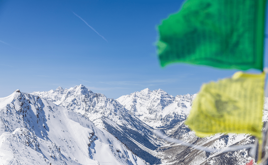 Maroon Bells during the winter, the prayer flags of the highlands bowl wave in the side of the image