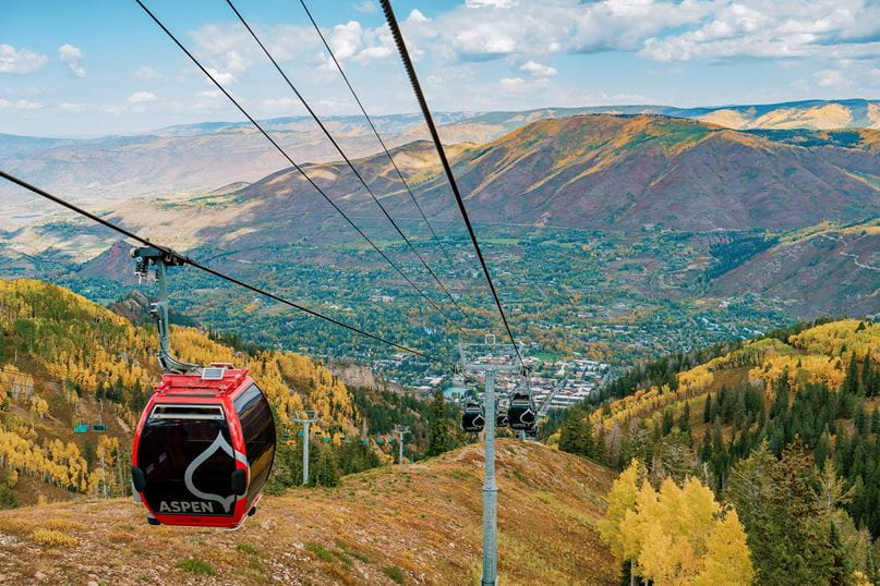 fall in aspen snowmass, gondola car carries passengers up aspen mountain to hike and sightsee in the fall leaves