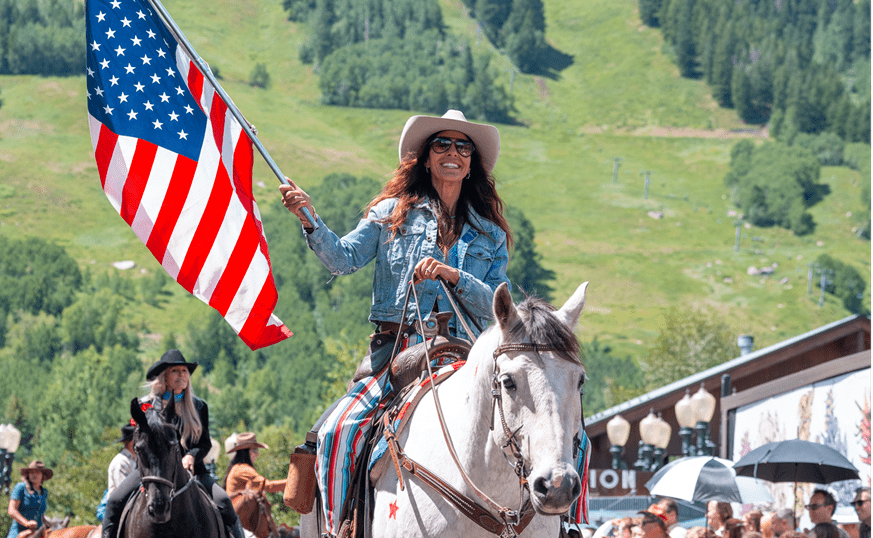 Women riding a horse holding the American flag