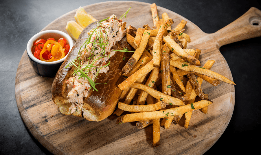 Lobster roles and truffle fries on a wooden board at Ajax Tavern