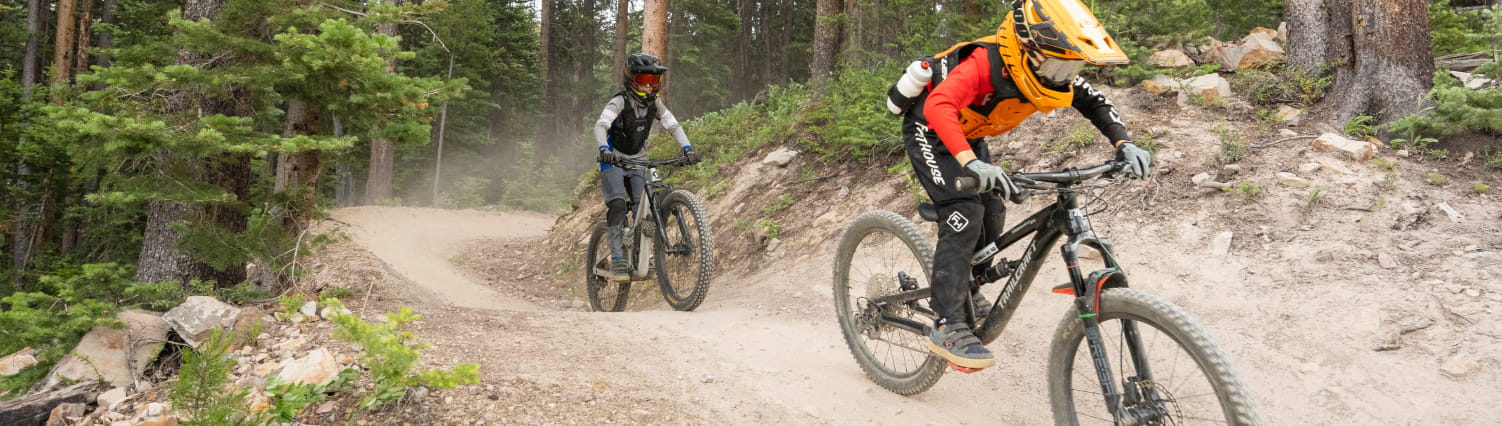 Two kids on downhill bikes