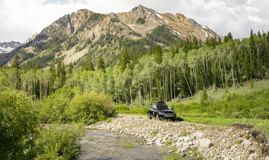 audi parked by river in Aspen on dirt road