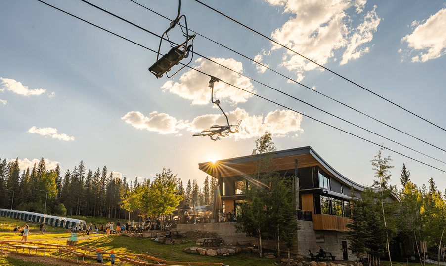 Elk camp chair over Elk Camp, blue skies with sun setting over the lift