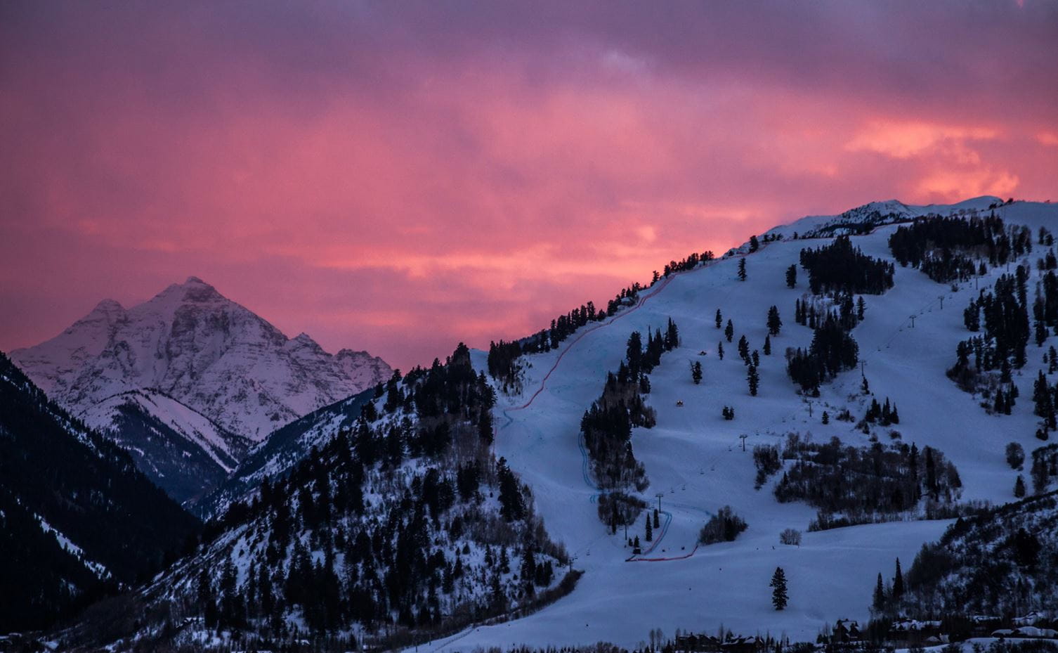 A pink sunset over Buttermilk and Pyramid Peak