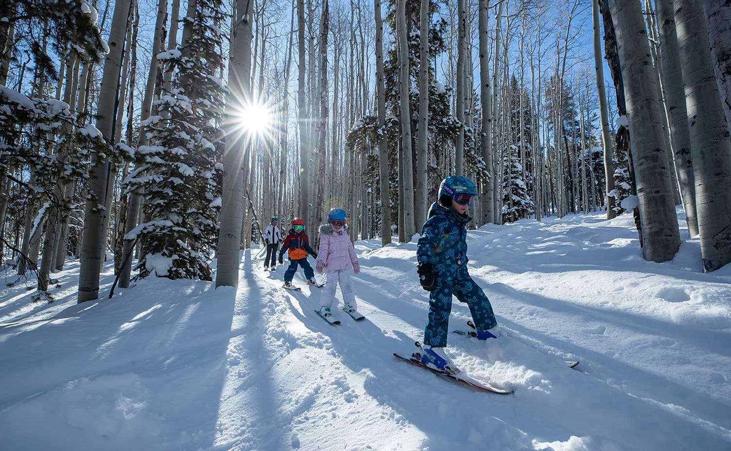 Kids skiing through the trees at Snowmass, Colorado