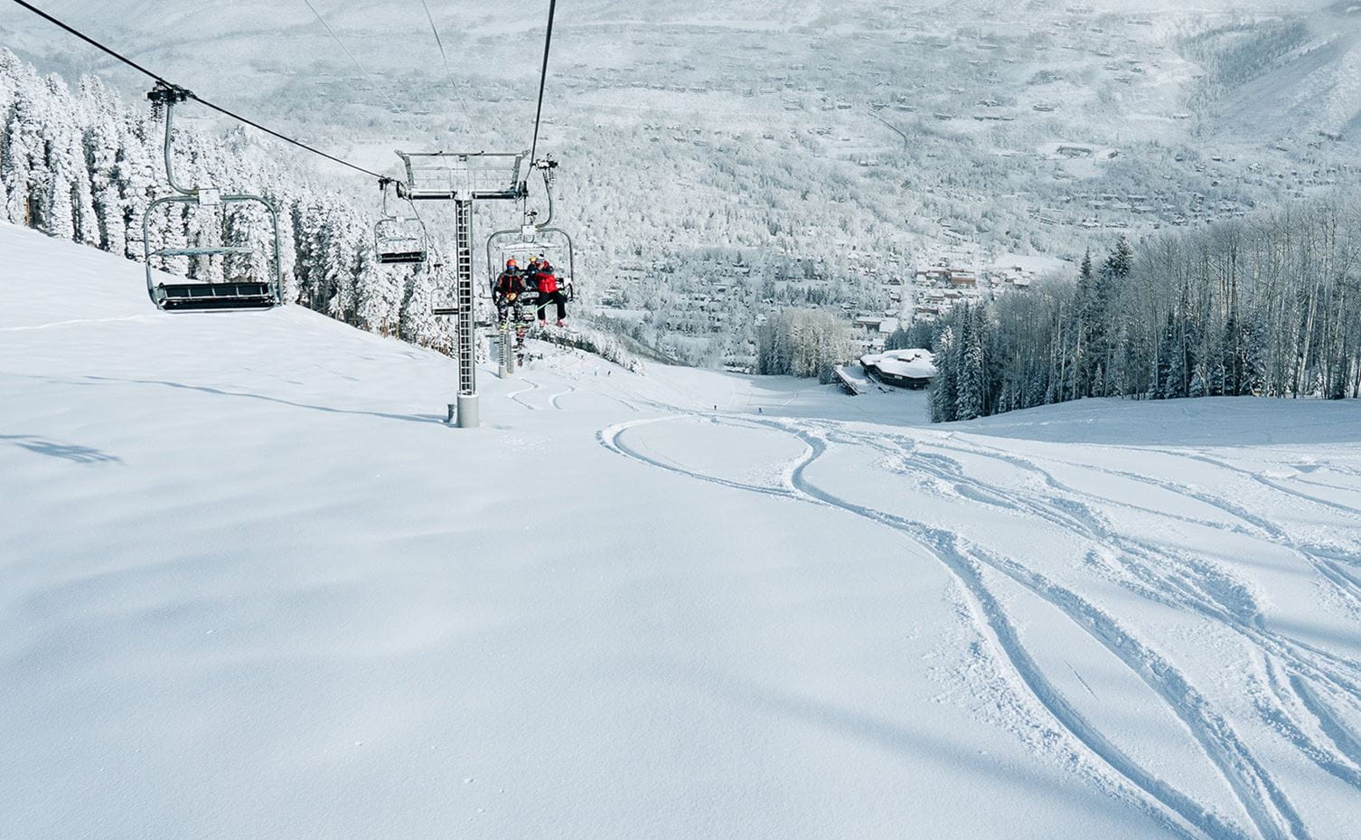 Skiers ride up a lift at Aspen Snowmass on a deep powder day