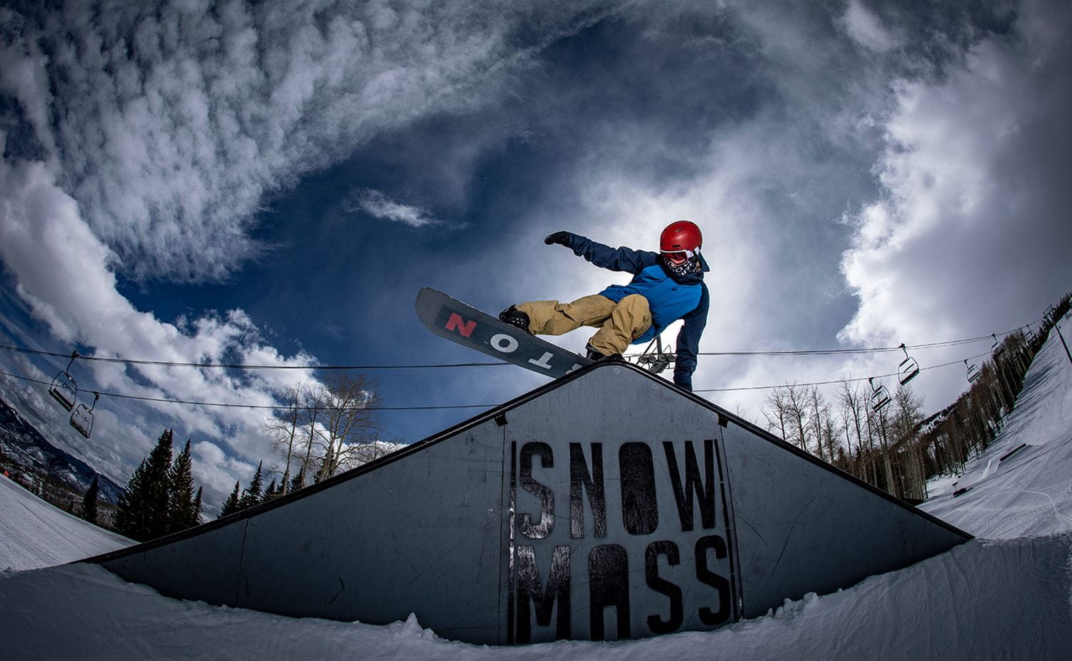 A snowboarder enjoys the pipes and rails and ramps at Snowmass