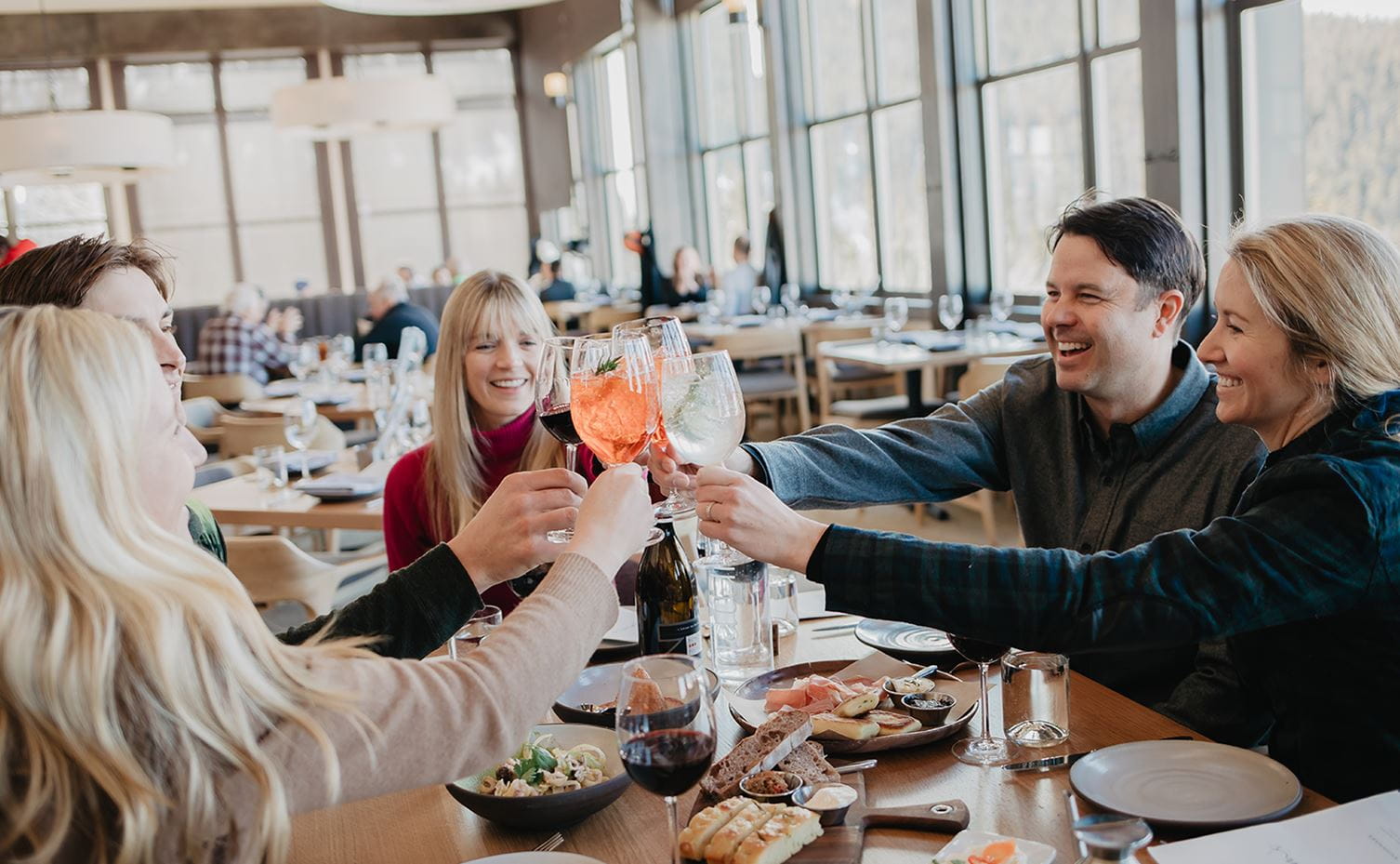 A group of friends toast at Sam's, one of many dining options at Snowmass