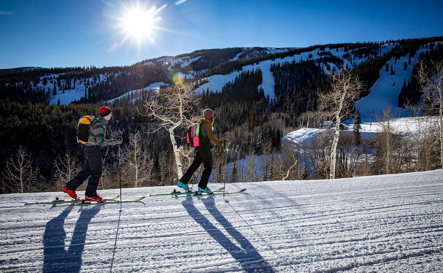 Two uphill skiers ascend Snowmass