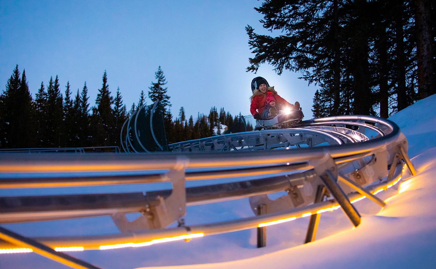 Riders enjoy the Breathtaker Alpine Coaster at night