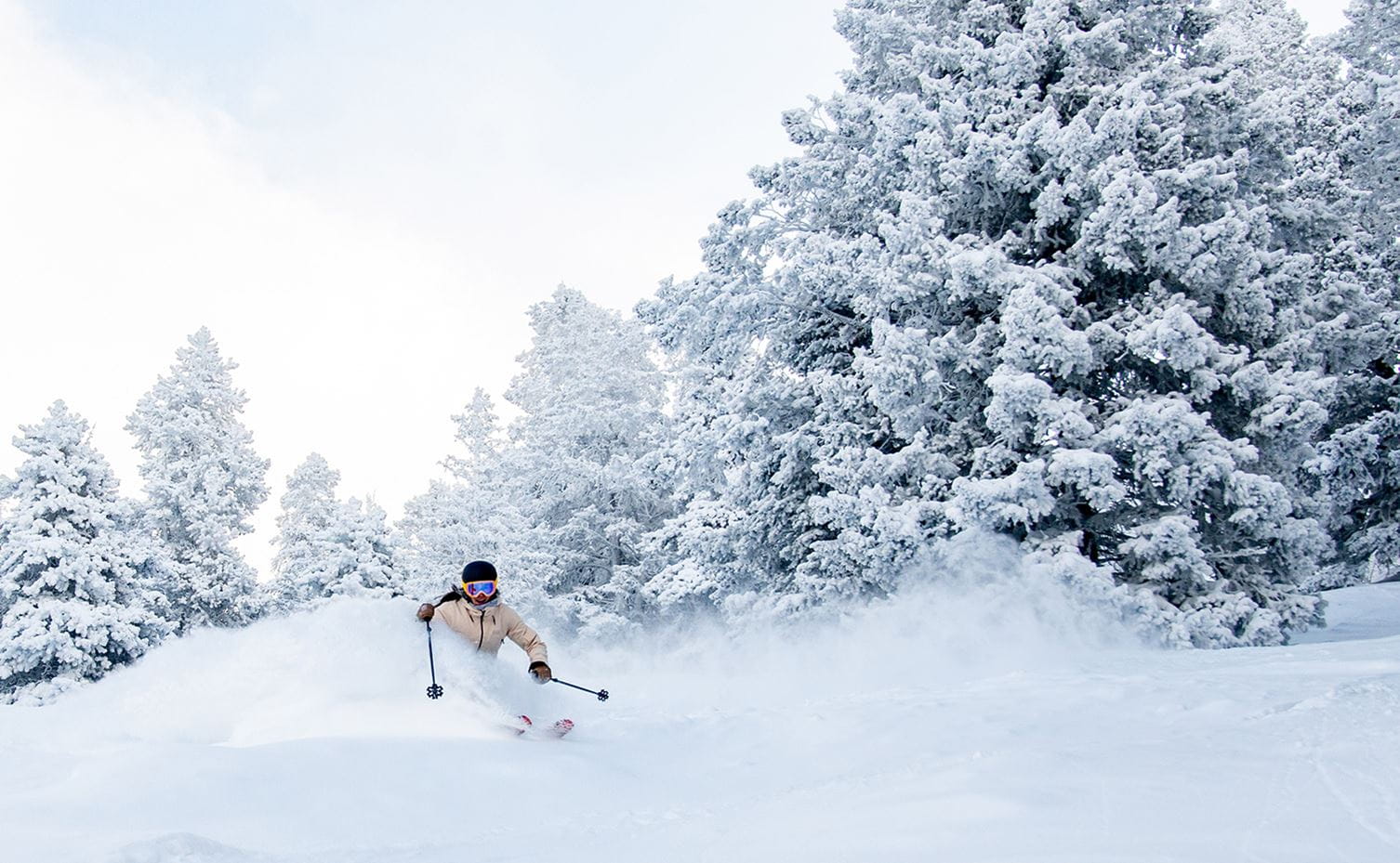 A skier rides through deep powder high up on Snowmass