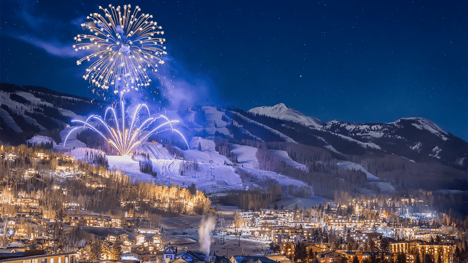 Town of Snowmass at night, fireworks light of the mountain as the town glows below