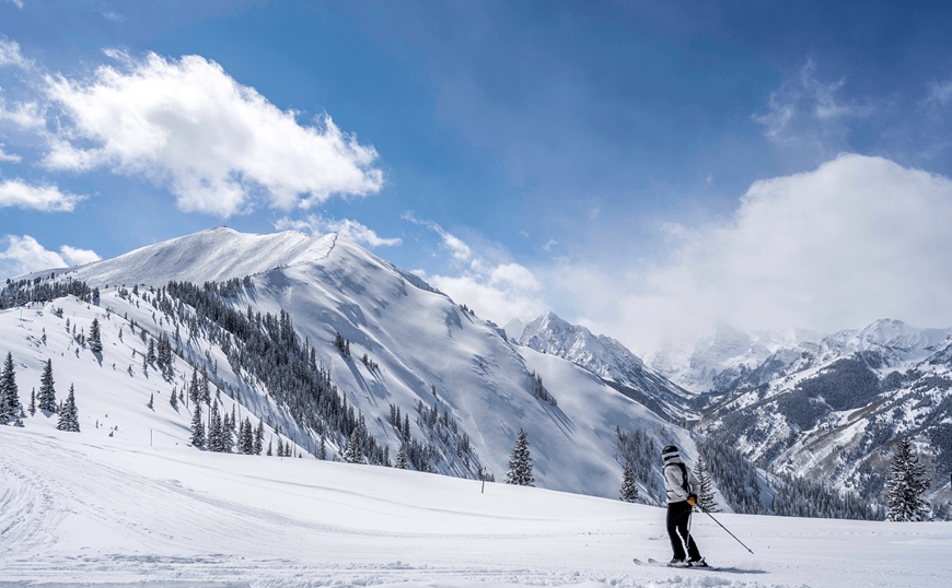 person skies over flat surface on the highlands bowl on a blue bird day
