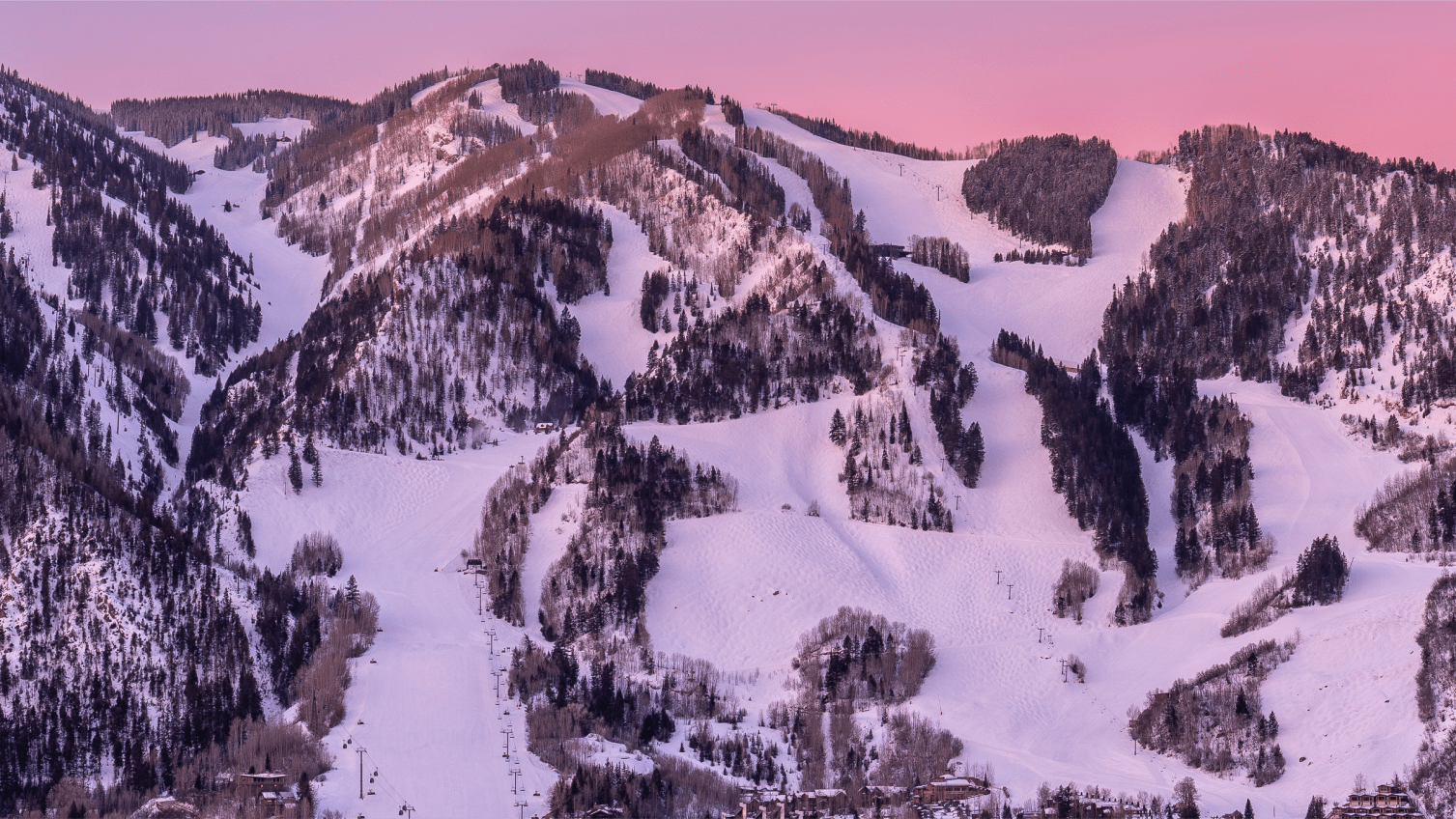 Pink skies over the winter, snow capped peaked of aspen mountain
