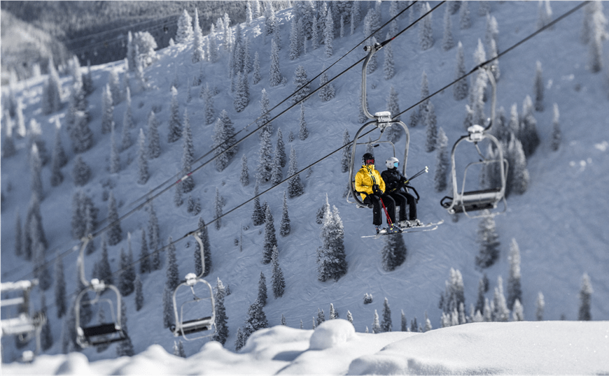 two people ride on a double ski lift, up bell mountain At Aspen Ski Resort