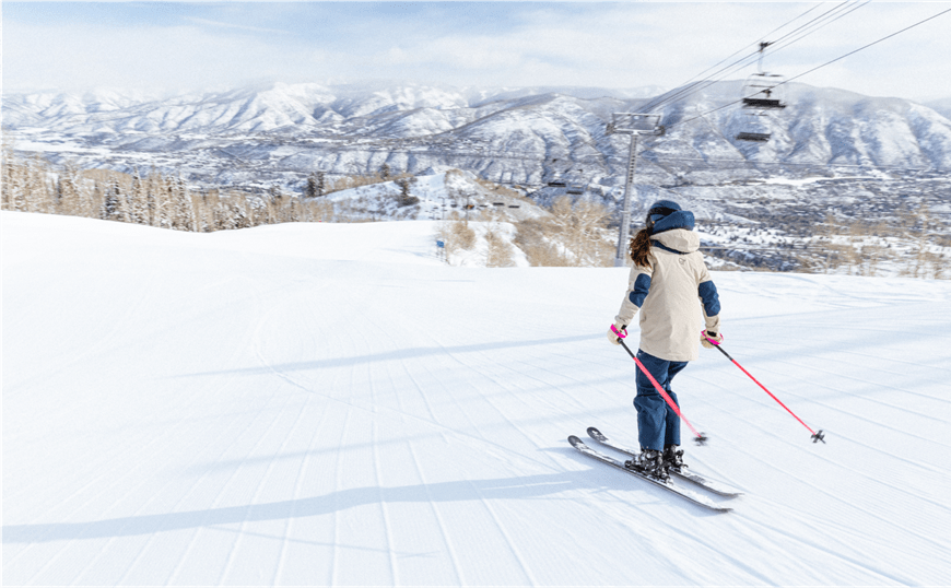 Woman skies down buttermilk groomed slope, no one else is on the run with her under the empty gondola