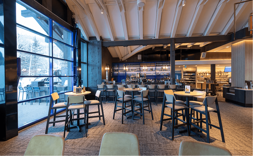 Interior view of the Buttermilk mountain lodge before opening, looking at the tall bar chairs and bar in the dining area