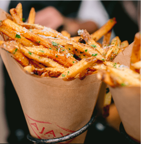 parm and truffel french fries in a paper holder at ajax tavern