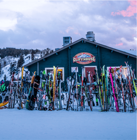The cliffhouse at buutermilk, skies stacked in front of green log cabin