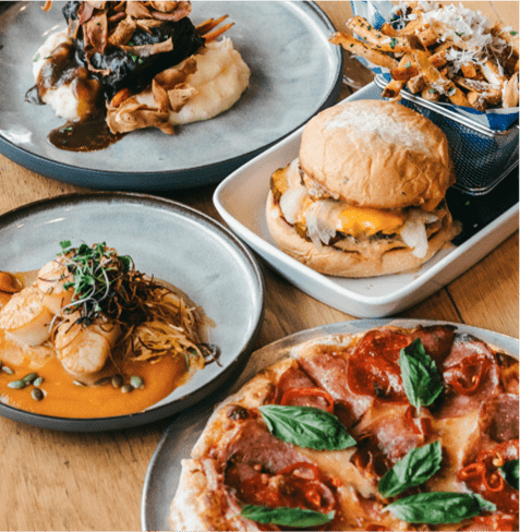 Various plates of food, pizza, burgers and fries, at Limelight Snowmass